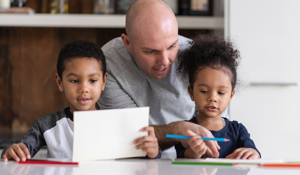 A father with his young son and daughter guiding schoolwork