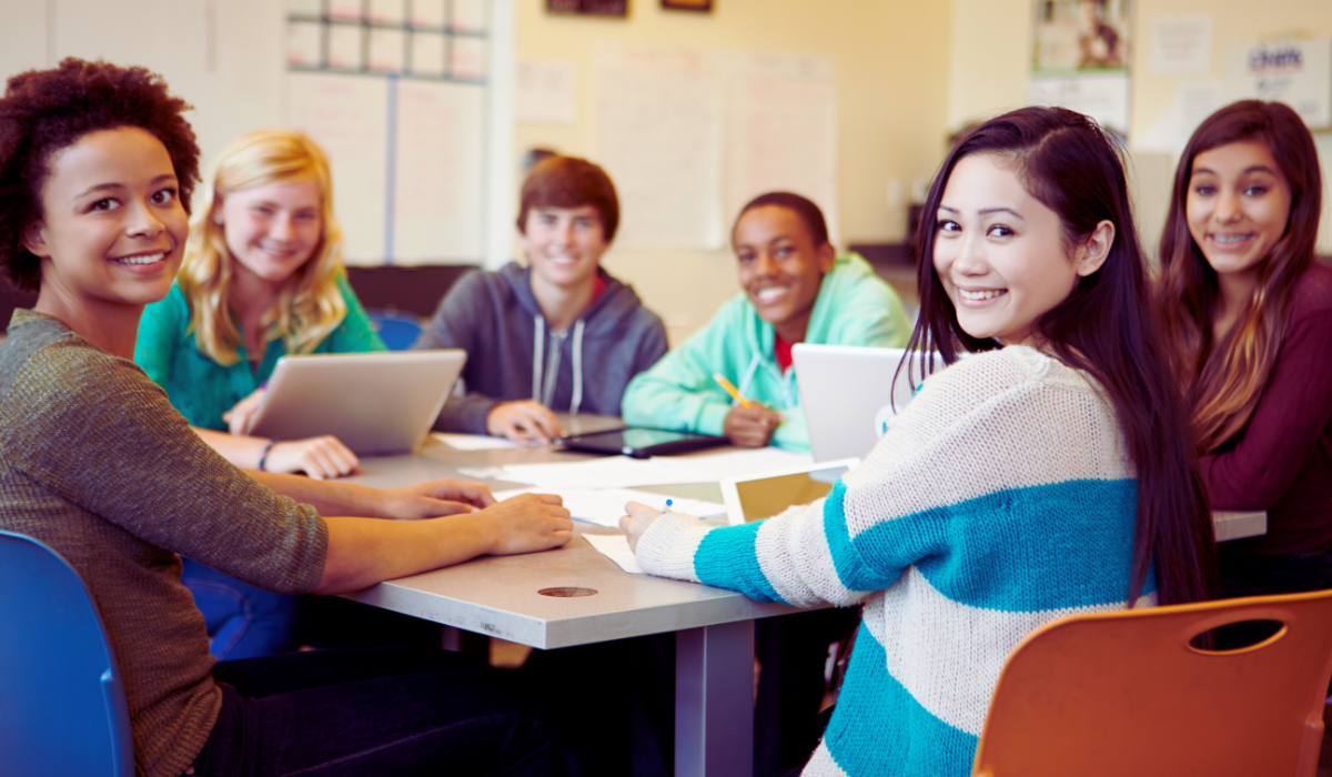 group of 6 teen students studying around a table