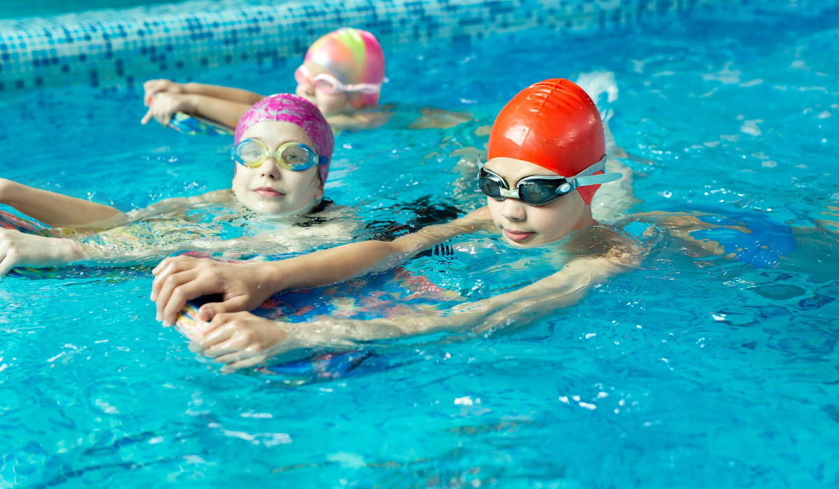 group of boys and girls learning to swim in a swim club