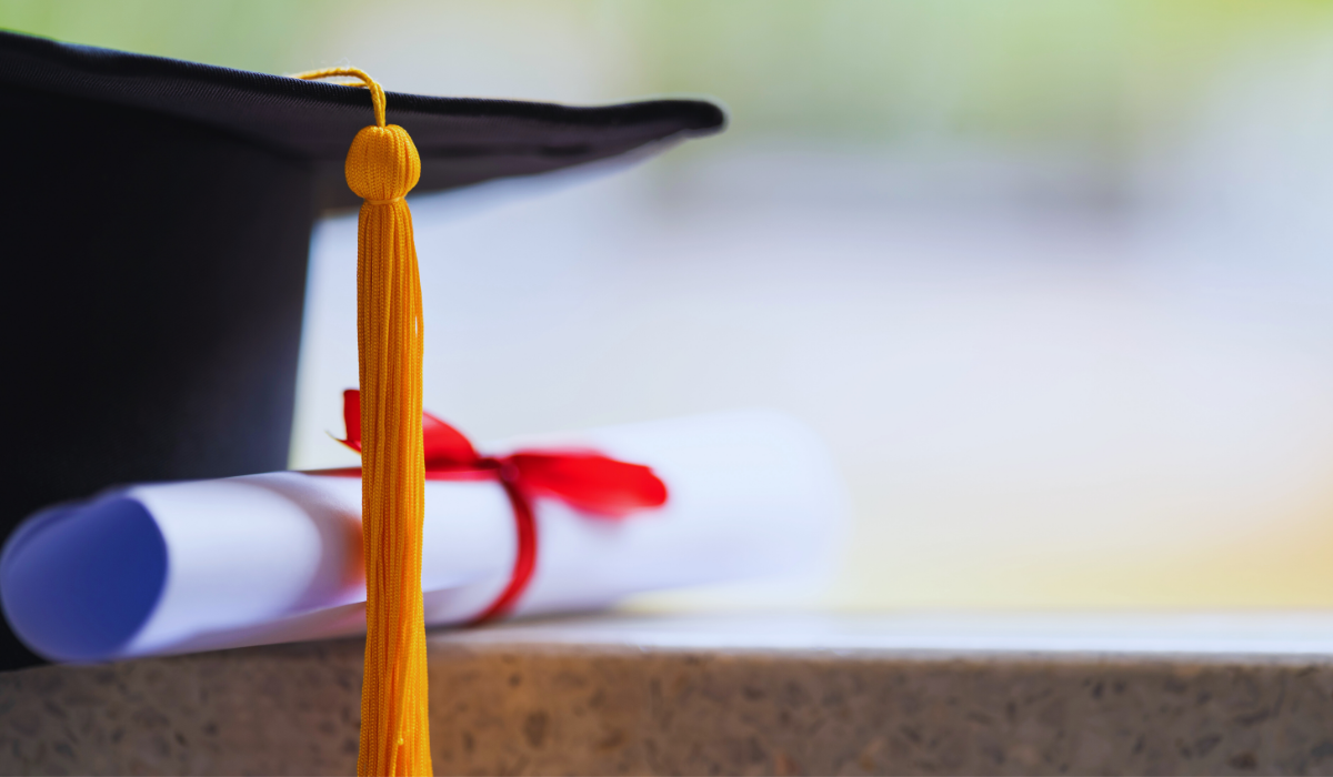 close up photo of graduation cap and rolled diploma