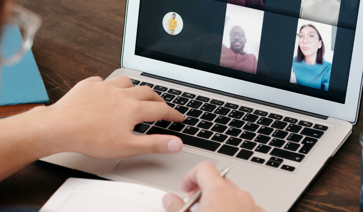 photo of a person at a desk participating in virtual meeting with other particiapnts