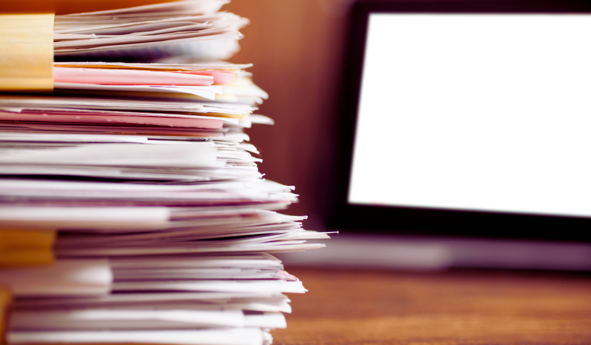 stack of folders in front of a computer