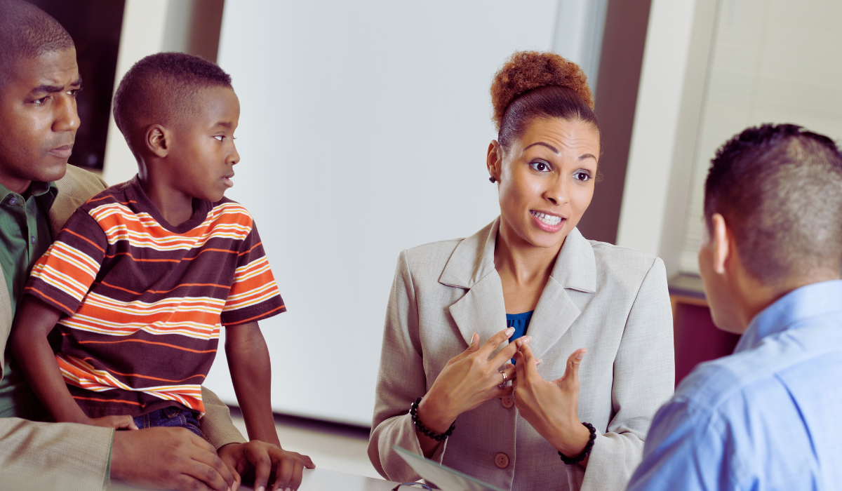 parents and student looking to an administrator during a meeting