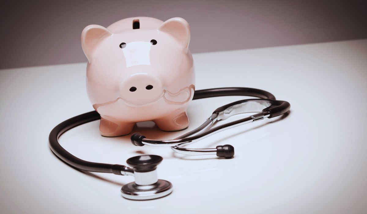 a white piggy bank sitting within a circle formed by a stethoscope