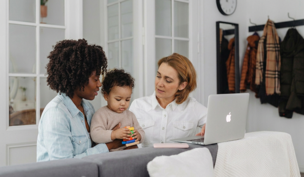 mom and child sitting with professional working on her computer